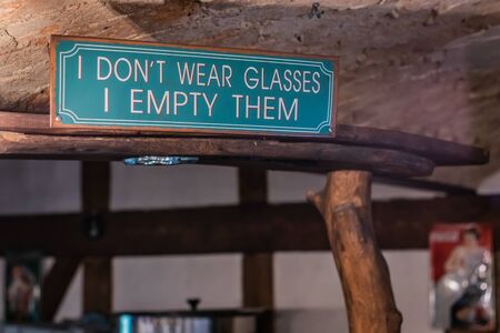 Funny inscription above the bar on a metal sign made of sheet painted green.の写真素材