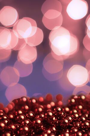 Christmas background, with blurred Christmas lights, beautiful bokeh and a chain of glossy balls in the foreground. Christmas decorationsの写真素材
