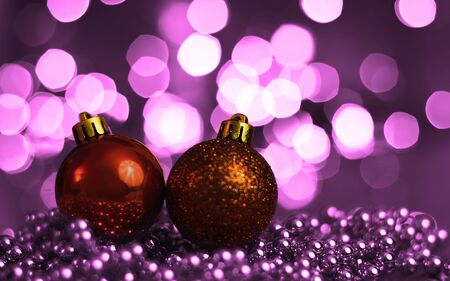 Two Christmas ornaments lying on balls of a Christmas chain on a blurred background with lights.の写真素材
