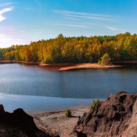 Beautiful autumn view of the iron mine lake colored red at Bad Muskau Park, Poland site.の写真素材