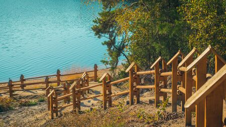 Path on the lake shore with wooden balustrades on a beautiful autumn day. Bad Muskau Park, Saxony, Germany.の写真素材