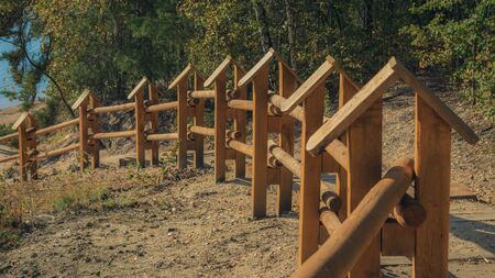 Path on the lake shore with wooden balustrades on a beautiful autumn day. Bad Muskau Park, Saxony, Germany.の写真素材