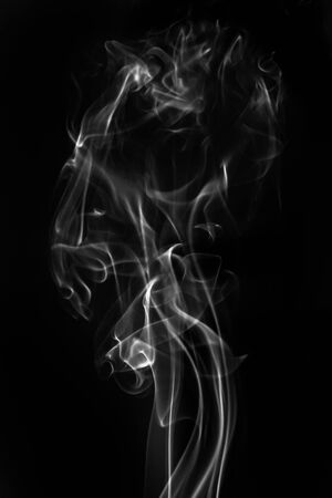 Gray smoke on a black background. Realistic incense smoke captured with a flash.の写真素材