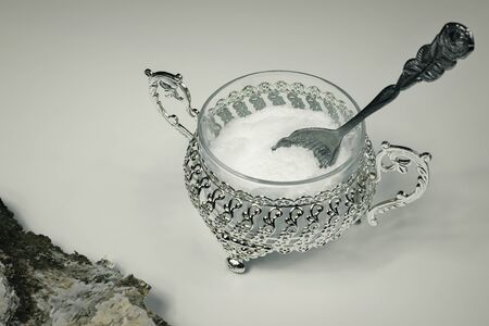 Xylitol in a metal decorative bowl with a rose-shaped spoon. Xylitol, a substitute for birch sugar for diabetics. A beautiful silver sugar bowl with xylitol or white sugar. Birch bark in the corner.の写真素材