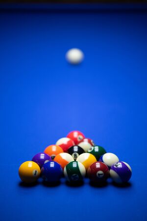 Colorful balls on a blue pool table. Set up and ready to play. Selective focus.の写真素材