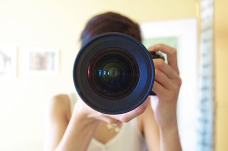 Close up view of woman holding a cameraの写真素材
