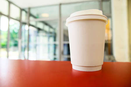 One paper coffee cup on the table. Blurred background.の写真素材