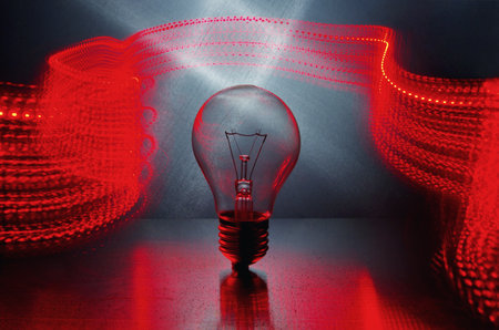 Power and light. Light bulb and red light in motion. Long exposure.の写真素材