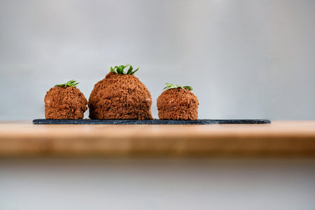Three chocolate mole cakes on the slate chopping board. Small Mole Hole cakes. Homemade cakes. Confectionery concept. Composition with blank space for a text.の写真素材