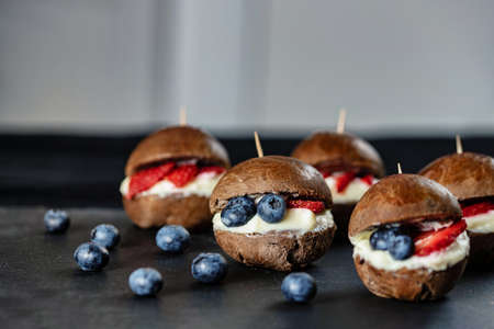 Original recipe. Choco burger with strawberries and blueberries. Small sweet burgers.の写真素材