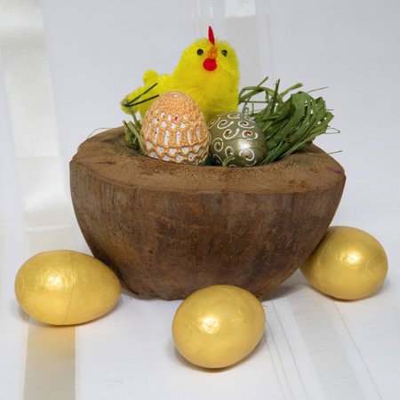 Easter decoration in coconut shell and gold eggsの写真素材