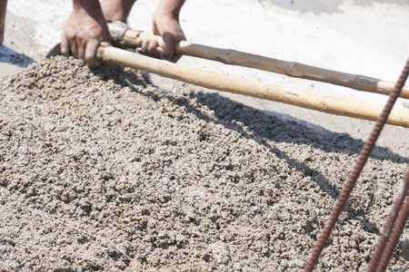 Worker pouring cement at the construction site, closeup of photoの写真素材
