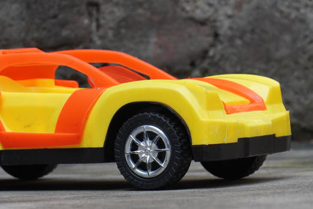Close up of yellow toy car on grey concrete background with copy spaceの写真素材