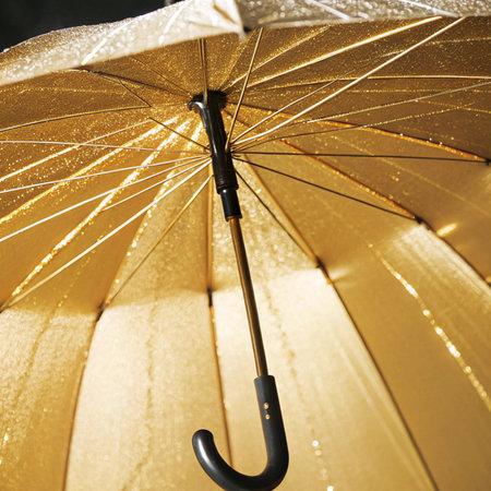 Close up of umbrella with gold and black stripes. Macro photography.の写真素材