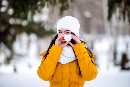 Heart of snow in the hands of a girl. Winter on the street.の写真素材
