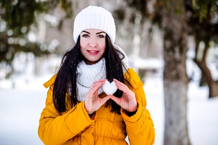 Heart of snow in the hands of a girl. Winter on the street.の写真素材