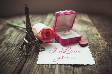 Declaration of love, the rose with a ring on a wooden board.の写真素材