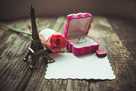 Declaration of love, the rose with a ring on a wooden board.の写真素材