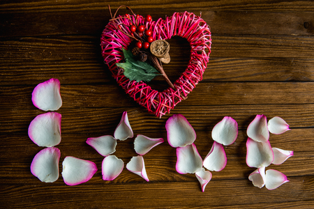 Caption word love on old wood background. Love inscription from the petals of roses.の写真素材