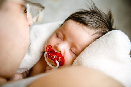 Dad holding newborn sleeping daughter in his arms. Close-upの写真素材