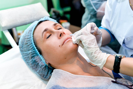 Senior woman getting skin care injection. Senior woman getting skin care injectionの写真素材