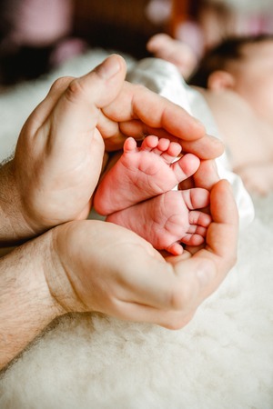 Baby legs. Legs newborn in parents handの写真素材