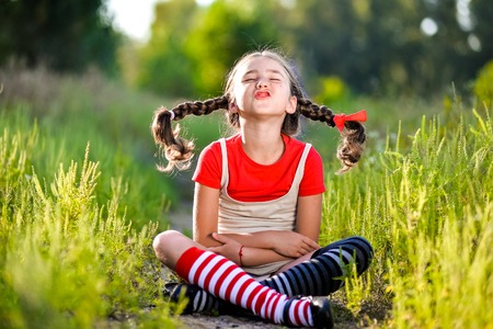 A funny cute outdoor portrait of a little girl making facial gestures.の写真素材