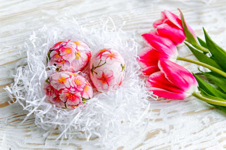 Decorated with painted Easter eggs and flowers on a light background. Decoupageの写真素材