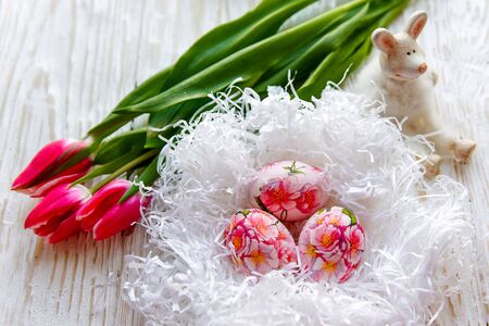 Decorated with painted Easter eggs and flowers on a light background. Decoupageの写真素材