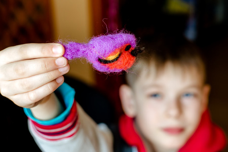 Manufacturing process from wool soft toys. Felting activity. The child makes a toy made of wool