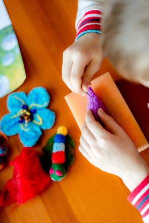 Manufacturing process from wool soft toys. Felting activity. The child makes a toy made of woolの写真素材