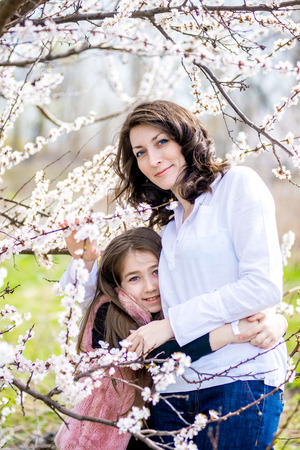 Mother and daughter walking in the garden in springの写真素材