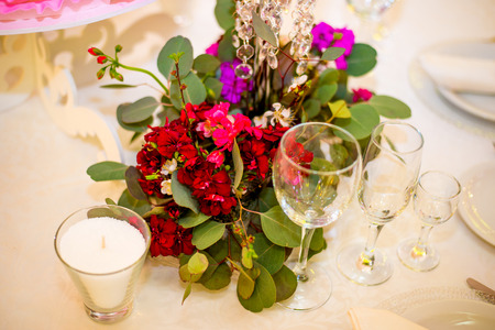 Beautifuly decorated wedding reception table covered with fresh flowers closeup. White and red rosesの写真素材