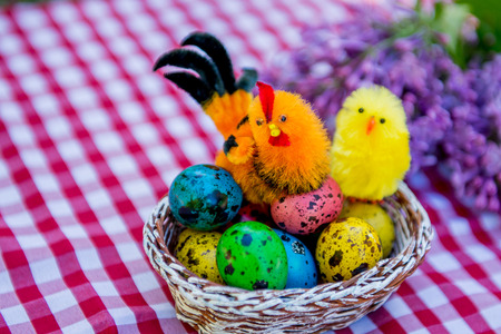 Painted easter eggs in nest on rustic wooden background,  happy easter card