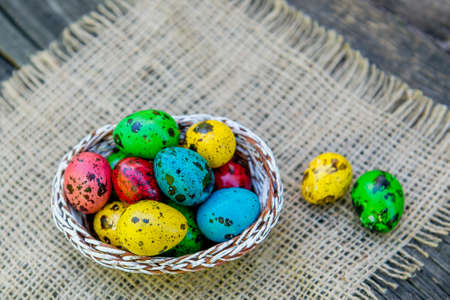 painted Easter quail eggs in a basket. Painted quail eggs at basketの写真素材