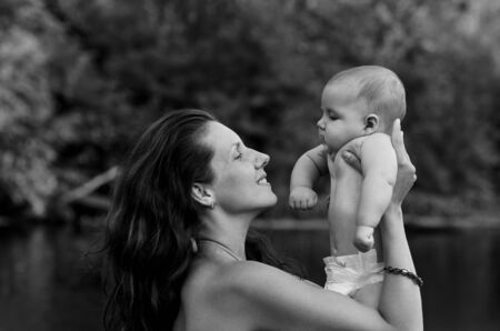 Mother embraces and kisses his little son on natureの写真素材