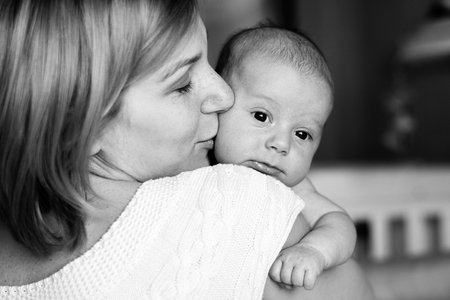 Portrait of happy mother and baby at home. The child is 2 months. black and white photoの写真素材