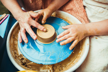 a child working on the potter's wheel makes the shape of a new product