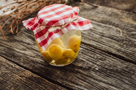 compote of grapes in a jar, standing on a wooden tableの写真素材