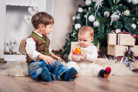 two brothers in anticipation of Christmas at the Christmas tree. Christmas decorationsの写真素材