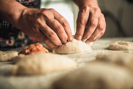 homemade cakes of the dough in the women's hands. The process of making pie dough by handの写真素材