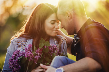 Close up profile portrait of an attractive young couple on holiday being romantic and kissing while relaxing during a summer break vacation. Love and relationships outdoors.の写真素材