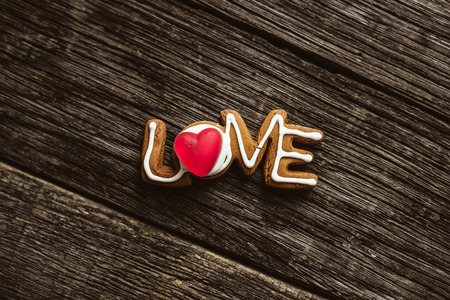 Word love spelled with home made cookies on a wooden table. Valentine's Day baking concept.の写真素材