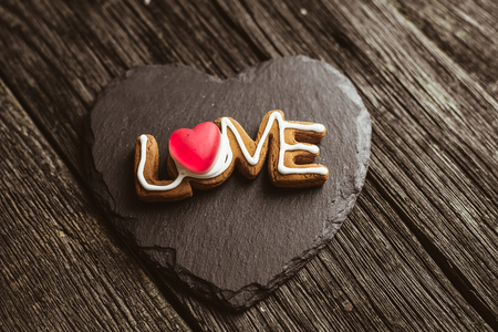 Word love spelled with home made cookies on a wooden table. Valentine's Day baking concept.の写真素材
