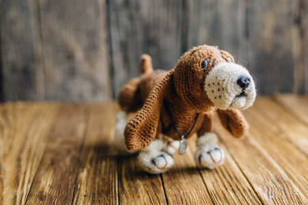Knitted dog Basset Hound isolated on wooden background. handmade toyの写真素材
