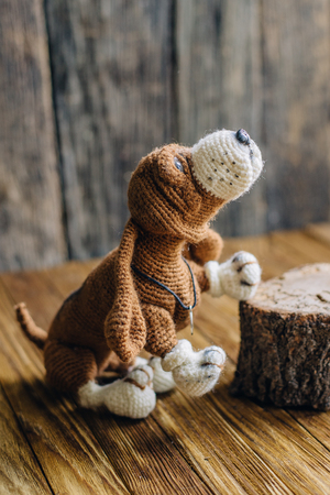 Knitted dog Basset Hound isolated on wooden background. handmade toyの写真素材