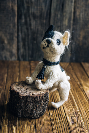 Knitted dog French Bulldogs isolated on wooden background. handmade toyの写真素材
