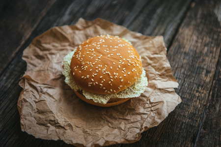 hamburger with chicken and lettuce on a wooden surfaceの写真素材