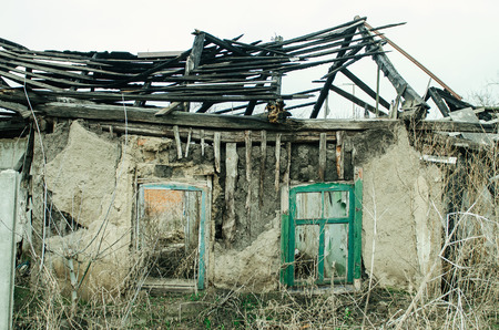 View of an old abandoned log house, finished with a plaster in a village.の写真素材