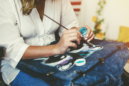 Artist paints picture on fabric with acrylic paints in her workshopの写真素材